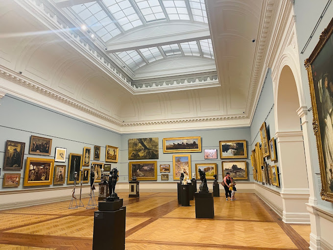 Gallery room at the Art Gallery of New South Wales with paintings hung on light blue walls