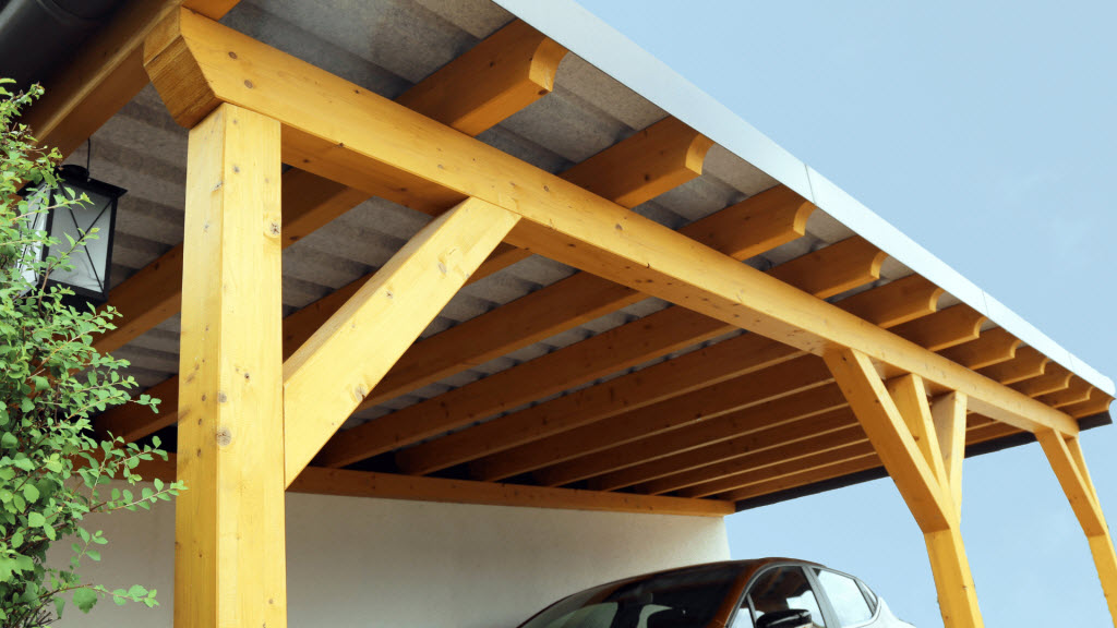 Timber-frame carport with a car parked underneath