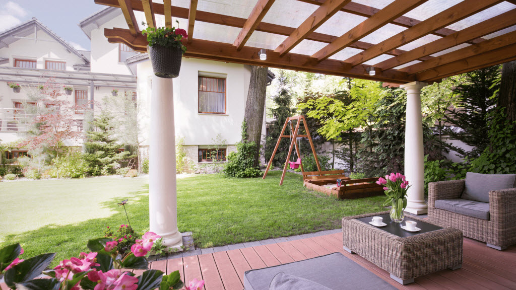 Timber pergola with a clear polycarbonate roof over a garden patio seating area