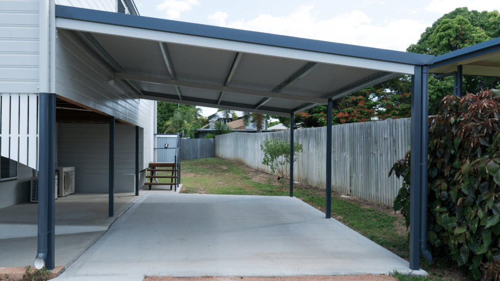 Steel-frame carport attached to a house driveway